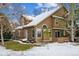 Charming two-story home features a side yard with mature trees and partial snow cover in a cozy neighborhood at 10654 W Dumbarton Cir # A, Littleton, CO 80127