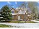 Inviting two-story home with manicured front yard, mature trees, and snow accents on a sunny winter day at 10654 W Dumbarton Cir # A, Littleton, CO 80127