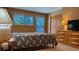 Well-lit bedroom featuring a comfortable bed, a wooden dresser, and a serene window view at 223 S Fuller Placer Rd # 4, Breckenridge, CO 80424