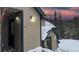 Inviting condo exterior with snowy rooftop, outdoor lighting, and beautiful mountain sunset in the background at 223 S Fuller Placer Rd # 4, Breckenridge, CO 80424