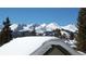 Panoramic view of snow-covered mountain peaks towering over trees, as seen from a snow-covered rooftop at 223 S Fuller Placer Rd # 4, Breckenridge, CO 80424