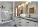 Bathroom featuring dual vanity sinks, modern lights, and large tile and glass shower at 1295 Hy Vu Dr, Evergreen, CO 80439
