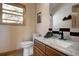 Powder room featuring a granite vanity with a modern faucet, light walls and window at 1295 Hy Vu Dr, Evergreen, CO 80439