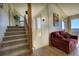 Inviting hallway with a cozy red couch, staircase, and large windows overlooking the landscape at 1295 Hy Vu Dr, Evergreen, CO 80439