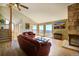 Bright living room featuring hardwood floors, stone fireplace, and a wall of windows at 1295 Hy Vu Dr, Evergreen, CO 80439