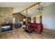 Open concept living room with stone fireplace, hardwood floors, and a view into the kitchen at 1295 Hy Vu Dr, Evergreen, CO 80439