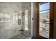 Tiled shower stall with glass door, black fixtures, and mountain views outside at 1295 Hy Vu Dr, Evergreen, CO 80439