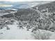 Picturesque winter view of a snow-covered landscape with evergreen trees and scattered houses at 1295 Hy Vu Dr, Evergreen, CO 80439