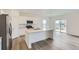 Bright kitchen with white cabinets, stainless appliances, island, and access to the outdoors at 15274 Milwaukee St, Thornton, CO 80602