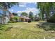 Expansive backyard featuring a well-maintained lawn, mature trees, and a covered patio ideal for outdoor entertaining and relaxation at 8664 E Monmouth Pl, Denver, CO 80237