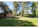 Lush backyard showcasing mature trees, a green lawn, and a serene garden area with seating, creating a peaceful outdoor retreat at 8664 E Monmouth Pl, Denver, CO 80237