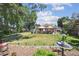 Spacious backyard featuring a well-manicured lawn, mature trees, and a charming patio area with outdoor seating at 8664 E Monmouth Pl, Denver, CO 80237