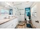 Bright bathroom boasts double sinks, decorative mirror, pebble stone shower with glass enclosure and beach themed decor at 8664 E Monmouth Pl, Denver, CO 80237