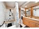 Bathroom featuring dual sinks with granite countertops and a bathtub with marble tile surround at 8664 E Monmouth Pl, Denver, CO 80237