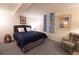 Bedroom with blue accent bedding, a patterned chair, and neutral carpeting at 8664 E Monmouth Pl, Denver, CO 80237