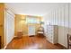 Bedroom with hardwood floors, a window with decorative curtains, and paneled walls at 8664 E Monmouth Pl, Denver, CO 80237