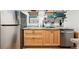 Kitchenette with stainless steel appliances, wood cabinets, and open shelving at 8664 E Monmouth Pl, Denver, CO 80237
