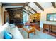 Comfortable living room features hardwood floors, wood beams, and a stone fireplace at 8664 E Monmouth Pl, Denver, CO 80237
