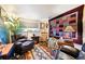 Eclectic living room featuring a decorative rug, a leather recliner, and an electric fireplace at 8664 E Monmouth Pl, Denver, CO 80237