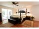 Bright main bedroom with hardwood floors, four-poster bed, and an abundance of natural light at 8664 E Monmouth Pl, Denver, CO 80237