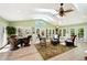 Bright sunroom boasts multiple doors to backyard, skylights, ceiling fan, and ample seating with a beautiful rug at 8664 E Monmouth Pl, Denver, CO 80237