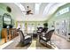 Bright, airy sunroom with multiple skylights, tile floors, ceiling fan, and charming wicker furniture at 8664 E Monmouth Pl, Denver, CO 80237
