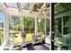 Charming sunroom with glass roof, large windows overlooking the backyard, and comfortable wicker seating at 8664 E Monmouth Pl, Denver, CO 80237