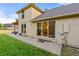 Back of house with paver patio, sliding glass doors, and manicured lawn at 6524 Surry Pl, Parker, CO 80134