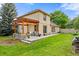 Spacious backyard with a covered patio featuring stone columns and paver flooring at 6524 Surry Pl, Parker, CO 80134