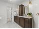 Bathroom with double sink vanity, a tall linen cabinet, and a doorway to another room at 6524 Surry Pl, Parker, CO 80134