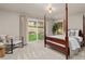 Bright bedroom with a four-poster bed, a sitting area, and sliding glass door to the yard at 6524 Surry Pl, Parker, CO 80134
