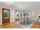 Bright dining room featuring a wood table, stylish chandelier, large windows and a decorative glass front door at 6524 Surry Pl, Parker, CO 80134