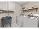 Laundry room with a utility sink, white washer and dryer, and upper cabinets at 6524 Surry Pl, Parker, CO 80134