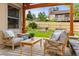 Inviting patio with comfortable seating under a wooden pergola and a well-manicured lawn at 6524 Surry Pl, Parker, CO 80134
