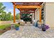 Inviting patio with a wooden pergola, stone columns, comfortable seating, and colorful potted plants at 6524 Surry Pl, Parker, CO 80134
