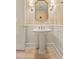 Elegant powder room features detailed wall paper, marble floors, a pedestal sink and vintage lighting at 6524 Surry Pl, Parker, CO 80134