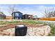 Landscaped backyard featuring a stone patio with a pergola and a fenced yard with scattered snow at 4512 S Yank St, Morrison, CO 80465