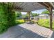 Shaded backyard patio with a wooden pergola, outdoor seating, and lush greenery at 4512 S Yank St, Morrison, CO 80465