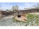 Backyard featuring a stone patio with built in seating and a fenced yard with scattered snow at 4512 S Yank St, Morrison, CO 80465