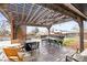 Outdoor patio with wooden pergola, fire pit, and dining area set up offers a relaxing outdoor retreat at 4512 S Yank St, Morrison, CO 80465