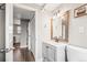 Well-lit bathroom featuring modern vanity with shaker cabinets and convenient access to laundry area at 4512 S Yank St, Morrison, CO 80465