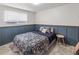 Cozy bedroom with wainscotting, floral comforter, and natural light from the window at 4512 S Yank St, Morrison, CO 80465