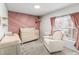 Comfortable Bedroom featuring textured accent wall, plush carpeting, and sun-filled window with custom curtains at 4512 S Yank St, Morrison, CO 80465