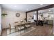 Open-concept dining area with wood flooring, a modern table, and a view into the adjacent kitchen at 4512 S Yank St, Morrison, CO 80465