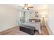 Bright bedroom with a queen-sized bed, tufted storage bench, sliding glass doors, and modern light fixture at 955 Eudora Street St # 108E, Denver, CO 80220
