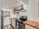 Updated kitchen, featuring stainless steel appliances and wood shelving at 3351 S Monaco Pkwy # F, Denver, CO 80222