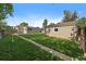 Wide view of backyard featuring green lawn and a patio area with a table and chairs at 1705 W Stoll Pl, Denver, CO 80221