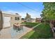 Spacious backyard with a patio, outdoor dining set, lush lawn, and detached garage at 1705 W Stoll Pl, Denver, CO 80221