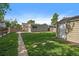 Lush backyard with green grass, a detached garage, and an outdoor dining area at 1705 W Stoll Pl, Denver, CO 80221