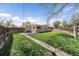 Landscaped backyard features green grass, a privacy fence, and patio with outdoor dining set at 1705 W Stoll Pl, Denver, CO 80221